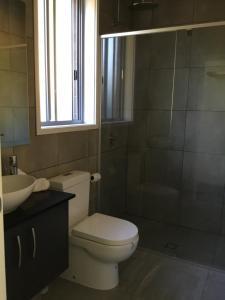 a bathroom with a toilet and a sink and a window at Giulia Guests Rooms in Beechmont