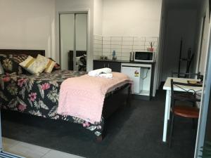 a bedroom with a bed with a pink blanket at Giulia Guests Rooms in Beechmont