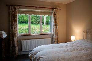 a bedroom with a bed and a large window at Cairn view in Mountfield