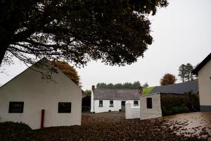 a white building with a tree in front of it at Cairn view in Mountfield
