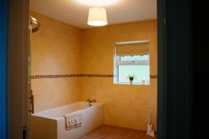 a bathroom with a tub and a window at Cairn view in Mountfield +26 photos