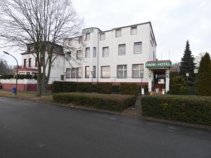 a white building with a sign that reads play hotel at Park Hotel in Hamm