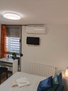 a room with a bed and a television on the wall at Armonía y tranquilidad habitaciones in Albacete