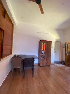 a room with a desk and a table and a chair at Wooden Villa in Kanchipuram