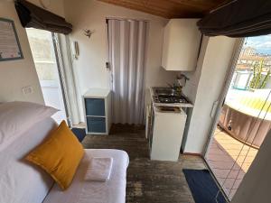 a small room with a bed and a kitchen with a stove at Tiny Nest Over Naples, Private Panoramic Terrace in Naples +17 photos