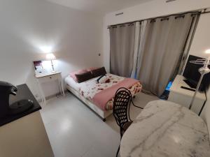 a small bedroom with a bed and a chair at Studio idéal cure ou séjour escapade in Balaruc-les-Bains