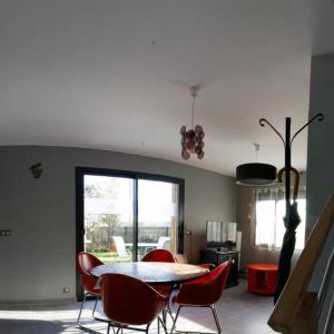 a dining room with a table and red chairs at Lapin in Lesquin