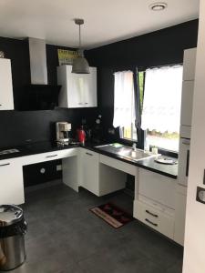 a kitchen with white cabinets and a sink and a window at Lapin in Lesquin +1 photo