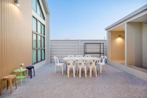 a group of white chairs and a table on a balcony at You Baan Pool Villa Cha-am in Ban Bo Prakhon