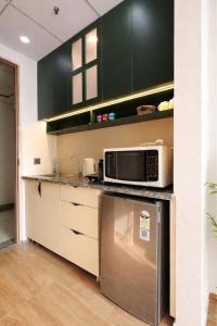 a kitchen with a stainless steel refrigerator and a microwave at Sunhaven Studio I Work & Leisure Stays I Near Expo Mart in Greater Noida +24 photos