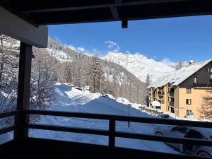 a view of a snow covered mountain from a window at Appartement Les chalets de Puy-St-Vincent 1700 in Puy-Saint-Vincent