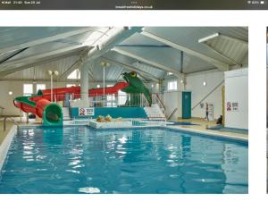 an indoor swimming pool with a slide and a water park at The Van 2 Thorness Bay Amenities are seasonal in Porchfield