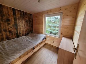 a small bedroom with a bed and a window at Domek nad Gopłem in Połajewek