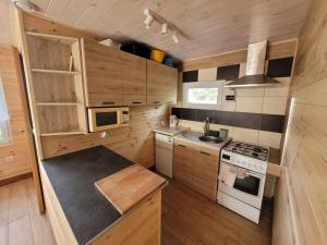 a small kitchen with wooden cabinets and a stove at Domek nad Gopłem in Połajewek
