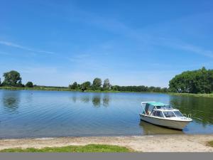 a small boat sitting on the shore of a lake at Domek nad Gopłem in Połajewek