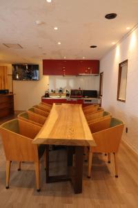 a conference room with a wooden table and chairs at Kamakura in Iiyama