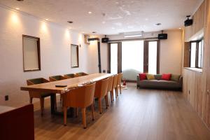 a dining room with a long table and chairs at Kamakura in Iiyama