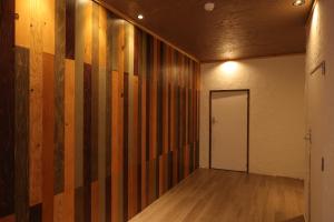 an empty room with a hallway with wooden walls and a door at Kamakura in Iiyama