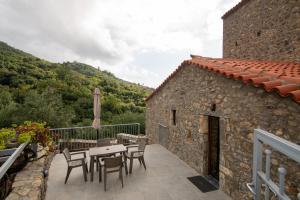 a stone house with a table and chairs on a balcony at Armonia Sun Tower in Exochori +24 photos