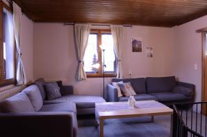 a living room with two couches and a table at Beim Patzelt - Ferienhaus in Nesselwang in Nesselwang