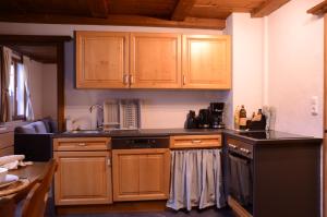 a kitchen with wooden cabinets and a black counter top at Beim Patzelt - Ferienhaus in Nesselwang in Nesselwang