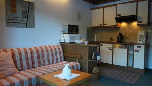 a living room with a couch and a kitchen at Landhaus Schmitte in Biberwier