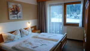 a bedroom with a bed and a large window at Landhaus Schmitte in Biberwier