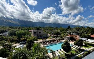 a resort with a pool and mountains in the background at Altos De Merlo Suites in Merlo