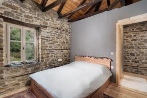 a bedroom with a bed in a brick wall at Villa Riverwood 
