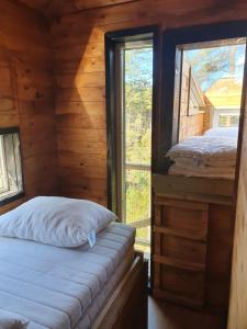 a bedroom with two beds in a log cabin at Gluba Treetop Cabins Elgposten in Harkmark