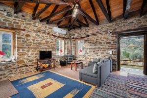 a living room with a stone wall with a couch and a television at Villa Riverwood 