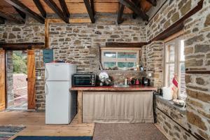 a kitchen with a white refrigerator in a stone wall at Villa Riverwood 