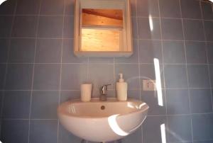 a white sink in a blue tiled bathroom at Tiny Nest Over Naples, Private Panoramic Terrace in Naples