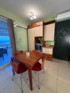 a kitchen and dining room with a wooden table and chairs at Glyfada Menigos Apartment 21 in Glyfada +24 photos