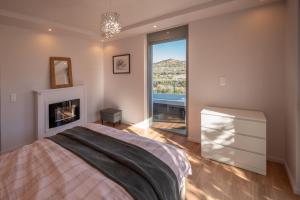 a bedroom with a bed and a fireplace and a window at Villa Tata - Private Pool, Garden & Mountain View near the Sea in Metókhi +53 photos