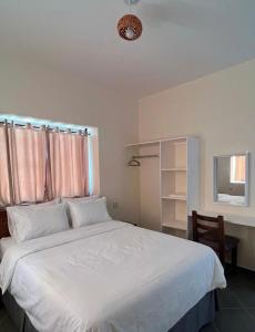 a bedroom with a large white bed with a window at Tazgha house in Essaouira +24 photos