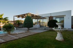 a house with a garden with a fountain in the yard at Villa Tata - Private Pool, Garden & Mountain View near the Sea in Metókhi