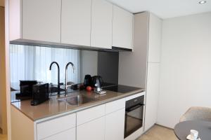 a kitchen with white cabinets and a sink at CITY STAY - Kieselgasse in Zurich