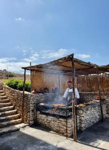 a man is cooking food on a grill at Tazgha house in Essaouira