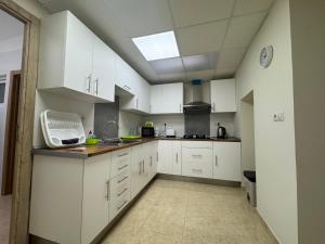 a large kitchen with white cabinets and a skylight at Casa Alan in Burriana