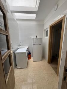 a kitchen with a white refrigerator and a ceiling at Casa Alan in Burriana +12 photos