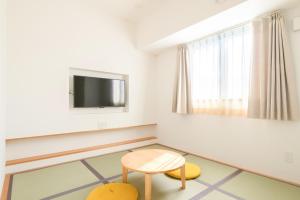 a living room with a table and a tv at Smile Hotel Miyakojima in Miyako-jima +30 photos