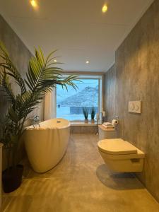 a bathroom with a large tub and a plant at The View XL in Senja