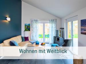 ein Wohnzimmer mit Sofa und Fernseher in der Unterkunft Traumweiler Ferienhäuser am Nationalpark Hunsrück Hochwald - barriearm - mit effektiver Kühlung in Kirschweiler