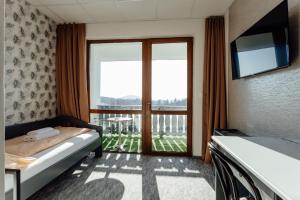 a bedroom with a bed and a large window at Penzión Topky in Banská Štiavnica