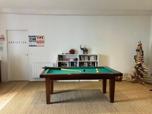 a room with a pool table and a christmas tree at Le Manoir des Sables - Hébergement familial grand confort in Berthegon