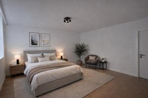 a bedroom with a large bed and a chair at Burgschelde 63 in Oudenaarde