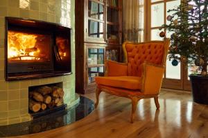 an orange chair in a living room with a fireplace at Santa Barbara House in Ratiševina