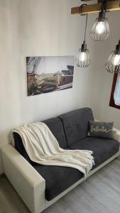 a couch in a living room with two lights at Frida Apartment in Chioggia +17 photos