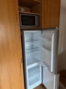 a refrigerator with its door open with a microwave at Ferienwohnung Landleben in Bühlertann
